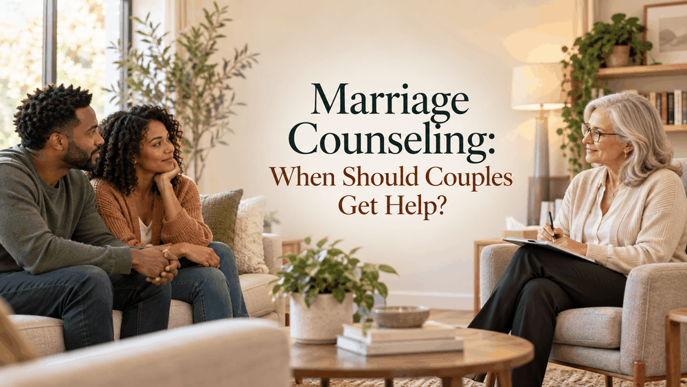 Married couple sitting together on a sofa during a marriage counseling session with a therapist taking notes
